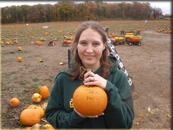 picture of Lara holding pumpkin with a diamond ring on top of it